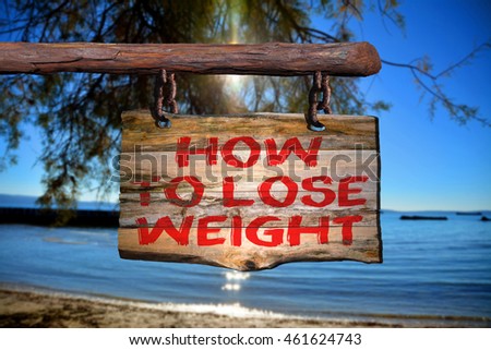 How to lose weight motivational phrase sign on old wood with blurred background
