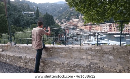 Man making photo with smart-phone in Portofino, Italy 