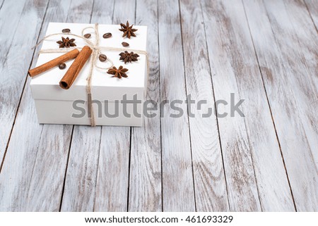 Christmas box decorated by cinnamon, anise, coffee, beans on the wooden background.Winter holidays concept. Space for text.