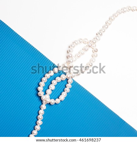 Flat lay. Top view. Fashion and beauty. Pearl necklace on creative background