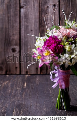Hands receiving a pastel bouquet from pink and purple gilly flowers