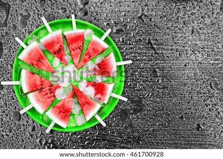 Slice of watermelon with ice cubes on a black background. Ice cream with the taste of watermelon. Sweet dessert. The summer mood.