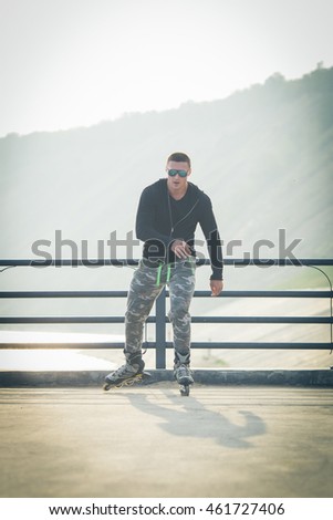 young man with inline skates ride in summer park outdoor roller skater