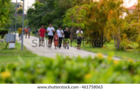 People walking or jogging in public park during evening for healthy and good life.Blurred image for background, maybe.