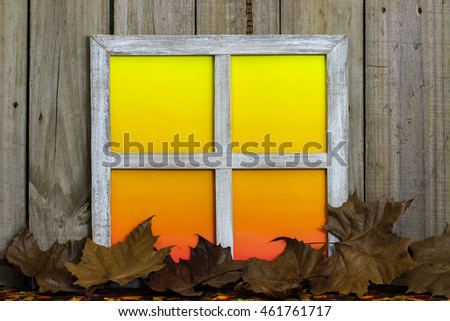 Rustic window with blank colorful window panes by fall leaves border with antique aged wood background; seasonal nature background with copy space