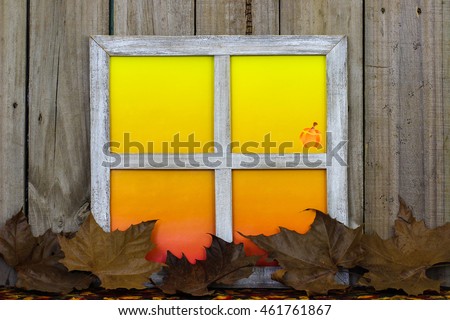 Rustic window with blank colorful window panes with pumpkin by fall leaves with antique aged wood background