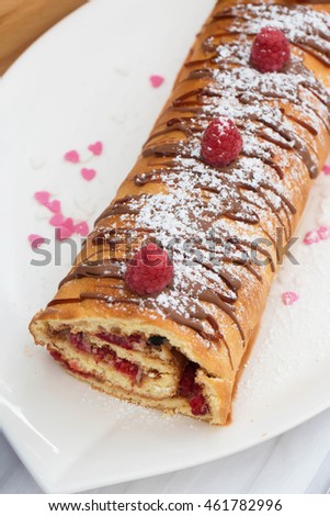 Homemade pastry roll filled with cream and berries. Natural light, selective focus.