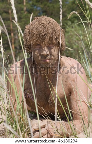 camouflage painted man masking in grass