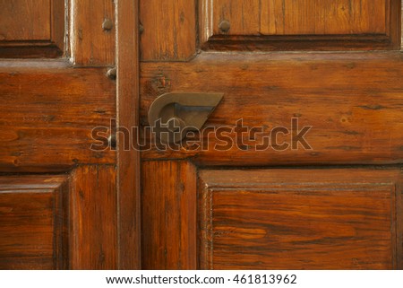 Red rustic wooden door with iron handle.