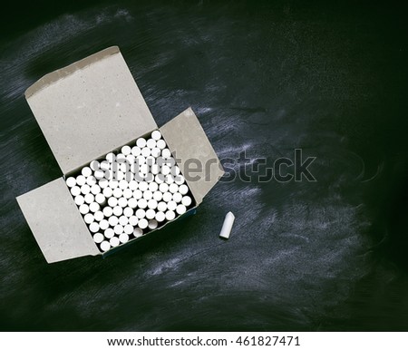 Box with pieces of chalk on the background of  blackboard