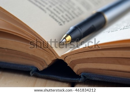 pen and book on wood background