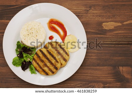 grilled meat with boiled rice and salad on white dish