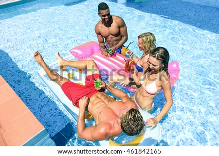 Young people drinking cocktails and having fun in swimming pool party - Cheerful friends enjoying vacation on hotel resort - Summer and holiday concept - Focus on bottom man - Top view - Warm filter