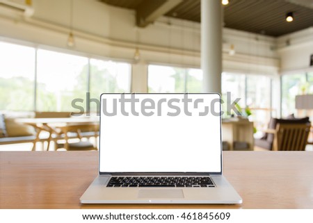 laptop with blank screen over wooden table indoor and blurred background