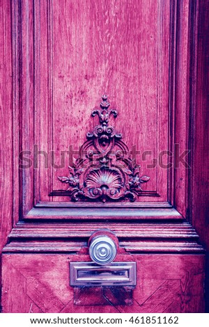 Old wooden door with floral carving. Paris, France. Toned photo.