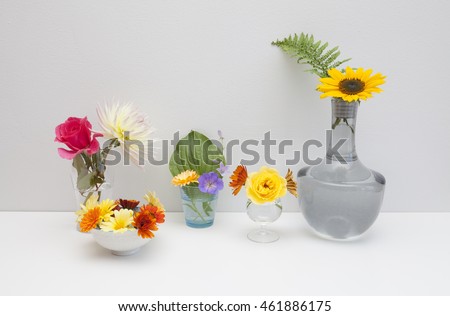 Interior composition with different kind of vases and colorful flowers on a white background