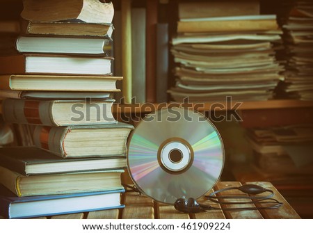 stack of books, library, cd, headphones, wooden table and bookcase