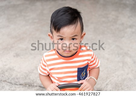 asian baby boy look up and feeling 
serious