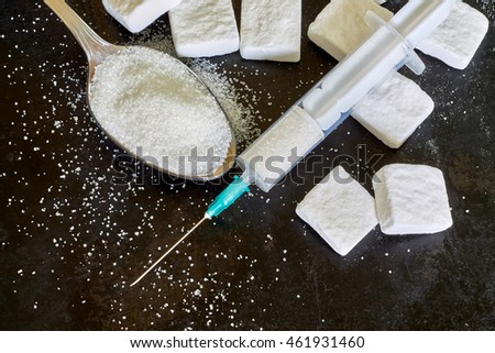 Injection with needle filled with sugar on black rustic background. Concept image for sugar addiction. Top view with copy space Royalty-Free Stock Photo #461931460