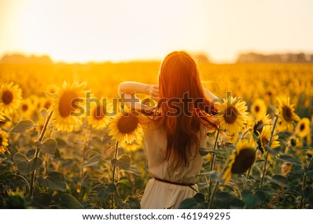 beautiful girl in the sunflowers in the sunset