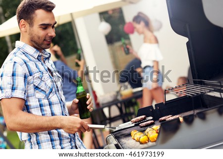 Picture of young man grilling food