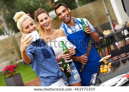 Picture presenting group of friends having barbecue party and taking selfie