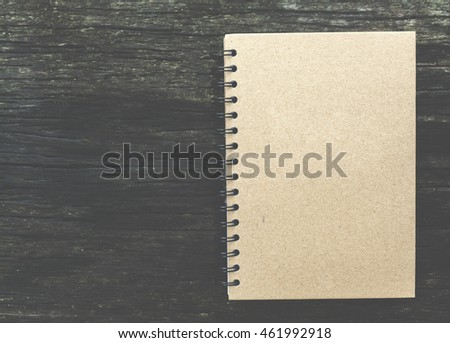 close note book on wooden background with vintage filter