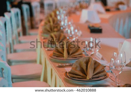 Blurred picture of beige serviette served over rich dinner plates
