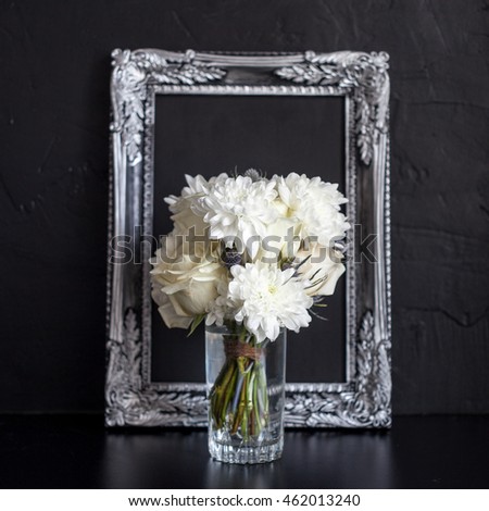 Vintage photo frame and flowers on a black textured background. Place for your text