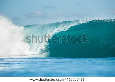 Shorebreak Big ocean wave in daylight. Beautiful sky with clouds. Sea Water surface for surfing sport front view . Nobody on picture. Vibrant bright tropical colorful image.