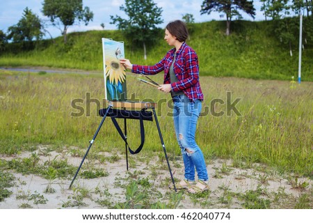 artist paints a picture of a woman on nature