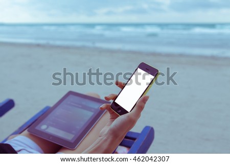Side view of a business woman working with a smartphone on holiday vintage effected color photo.
