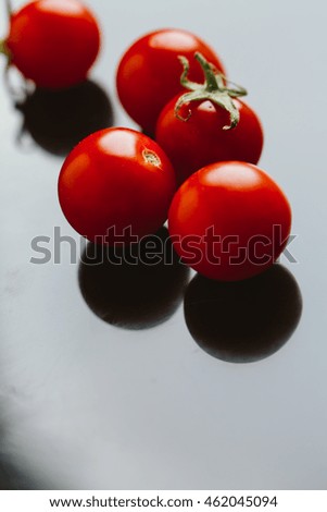 Fresh cherry tomatoes on a dark background.