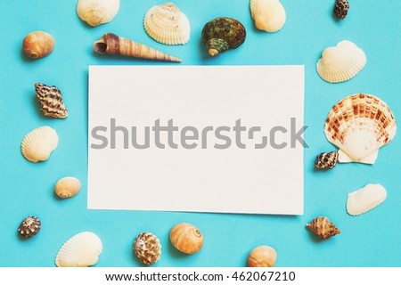 Summer background with colorful seashells. White sheet for the text. Flat lay, top view photography. Design elements
