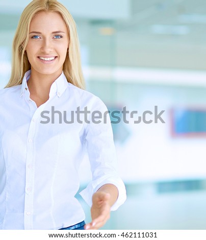 Young business woman ready to handshake standing in office