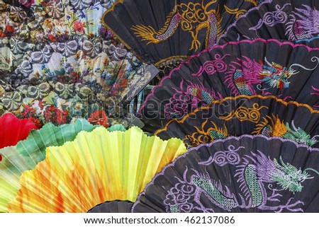 Colorful oriental hand fans in an outdoor market.