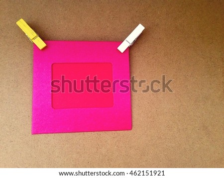 Paper attach with clothes pins on wooden background