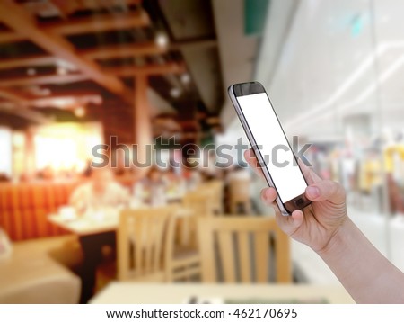 using mobile smart phone with restaurant blur background,Vintage filter