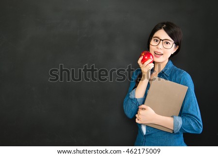 happy girl student with glasses and book in front blackboard in class