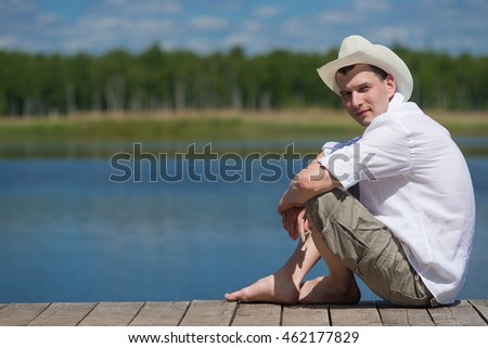 Man resting on nature while sitting on the pier