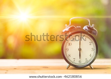 Retro 6 o'clock and Morning sun with Bright and Flare Day Light Blur Green Garden Background with space for text. Royalty-Free Stock Photo #462180856