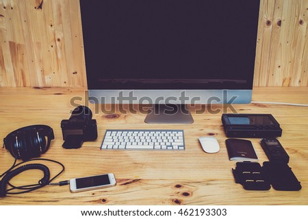 Office computer PC camera, mobile phone, headphone,sound recorder,passport,memory card,keyboard and mouse on wooden desk in vintage tone