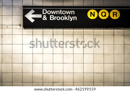 Subway sign in Manhattan directing passengers  and travelers to the downtown and Brooklyn trains