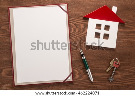 Blank paper, pen, key and house on wooden background 