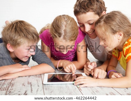 Children with tablet. Group kids playing 