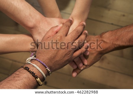 Close up view at group of hands holding together