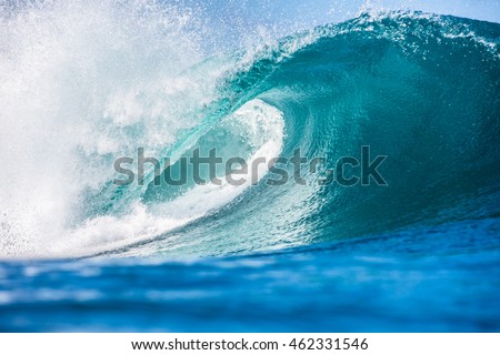 Shorebreak ocean wave in daylight. Beautiful sky with clouds. Sea Water surface for surfing sport. Nobody on picture. Vibrant bright tropical colorful image.
