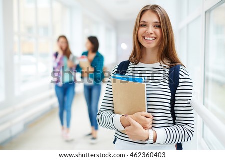 Portrait of beautiful smiing female college student Royalty-Free Stock Photo #462360403