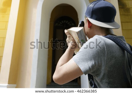 young man traveler is taking picture with the guide book , travel and recreation concept