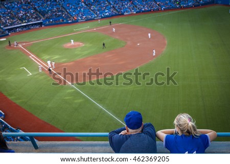 Man and woman watching a baseball game on the opening pitch Royalty-Free Stock Photo #462369205